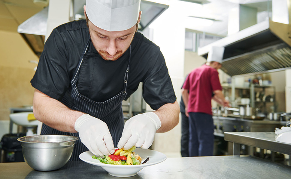 Cocinero elaborando producto y controlando el Stock de materia prima